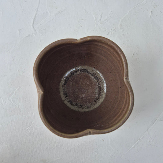 Brown ceramic flower-shaped cup
on a light gray background