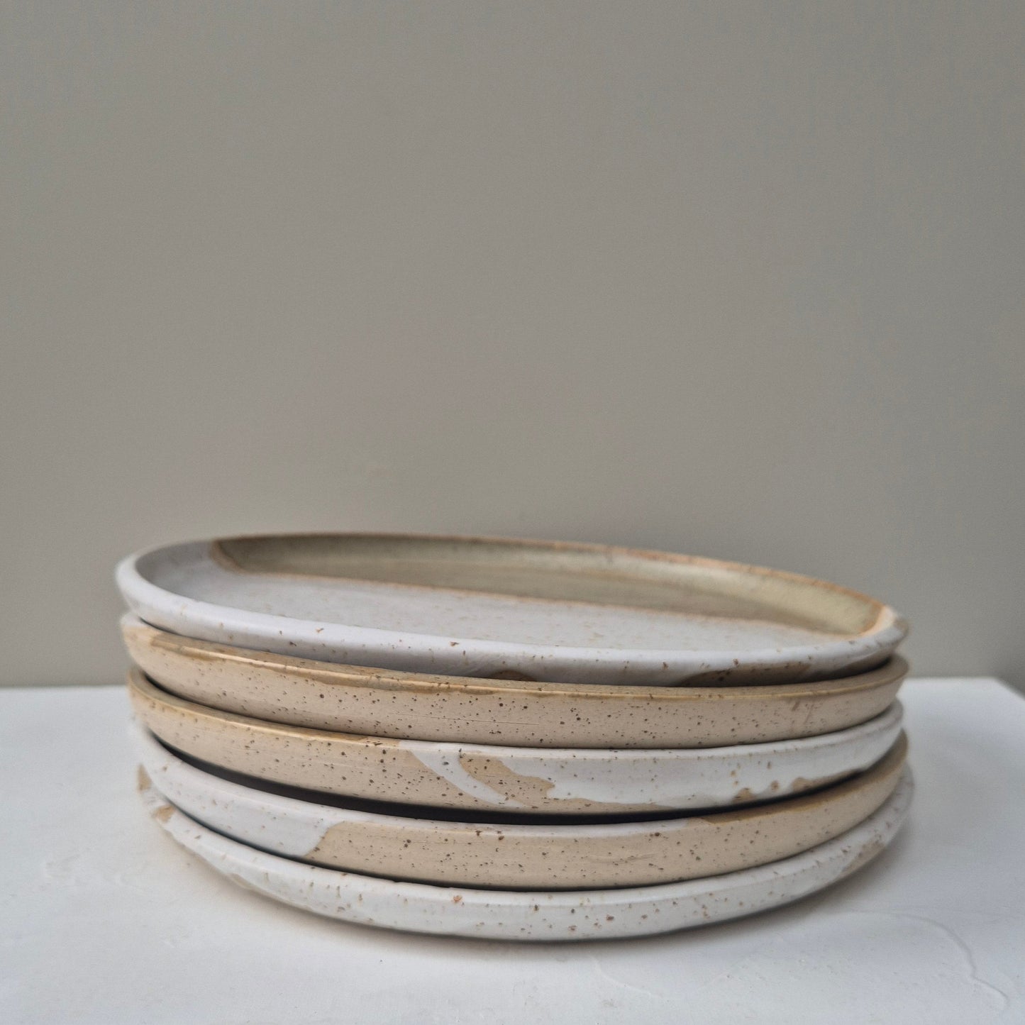 Set of three ceramic plates on a white surface with a neutral background
