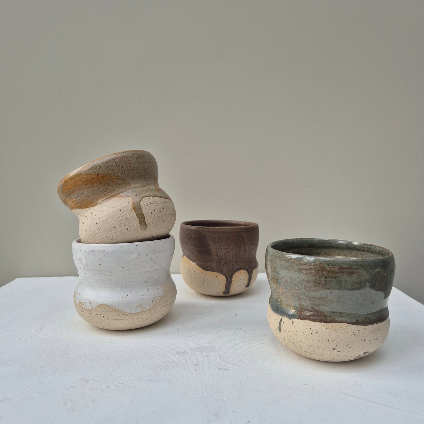 Set of three ceramic cups with a textured finish on a white surface.