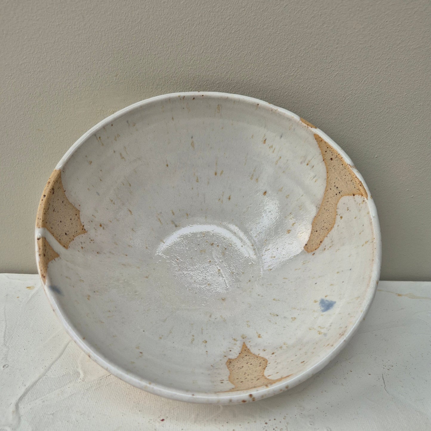 White ceramic plate with brown spots on a light gray background