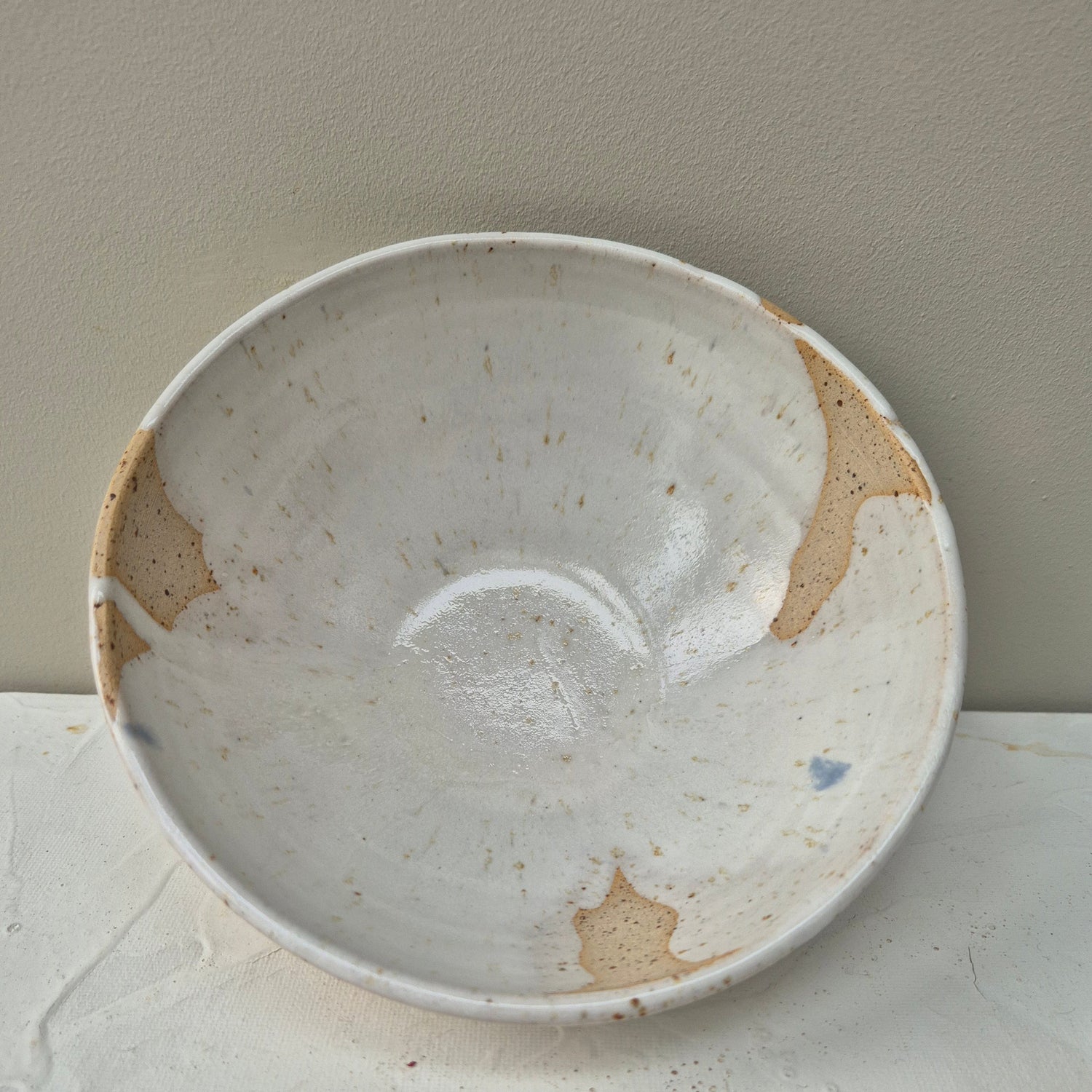 White ceramic plate with brown spots on a light gray background