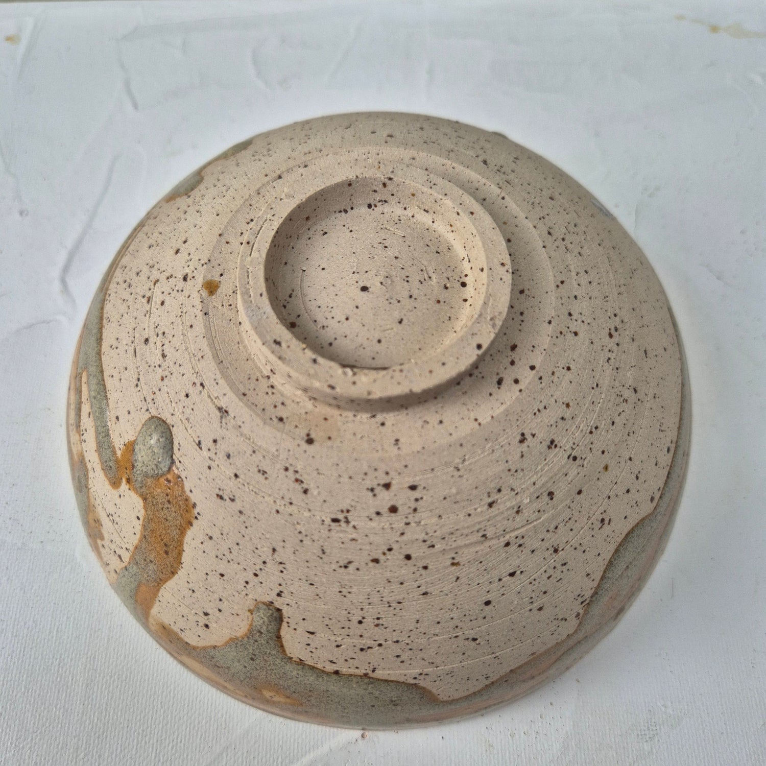 Close-up of a ceramic bowl with a textured surface on a white background