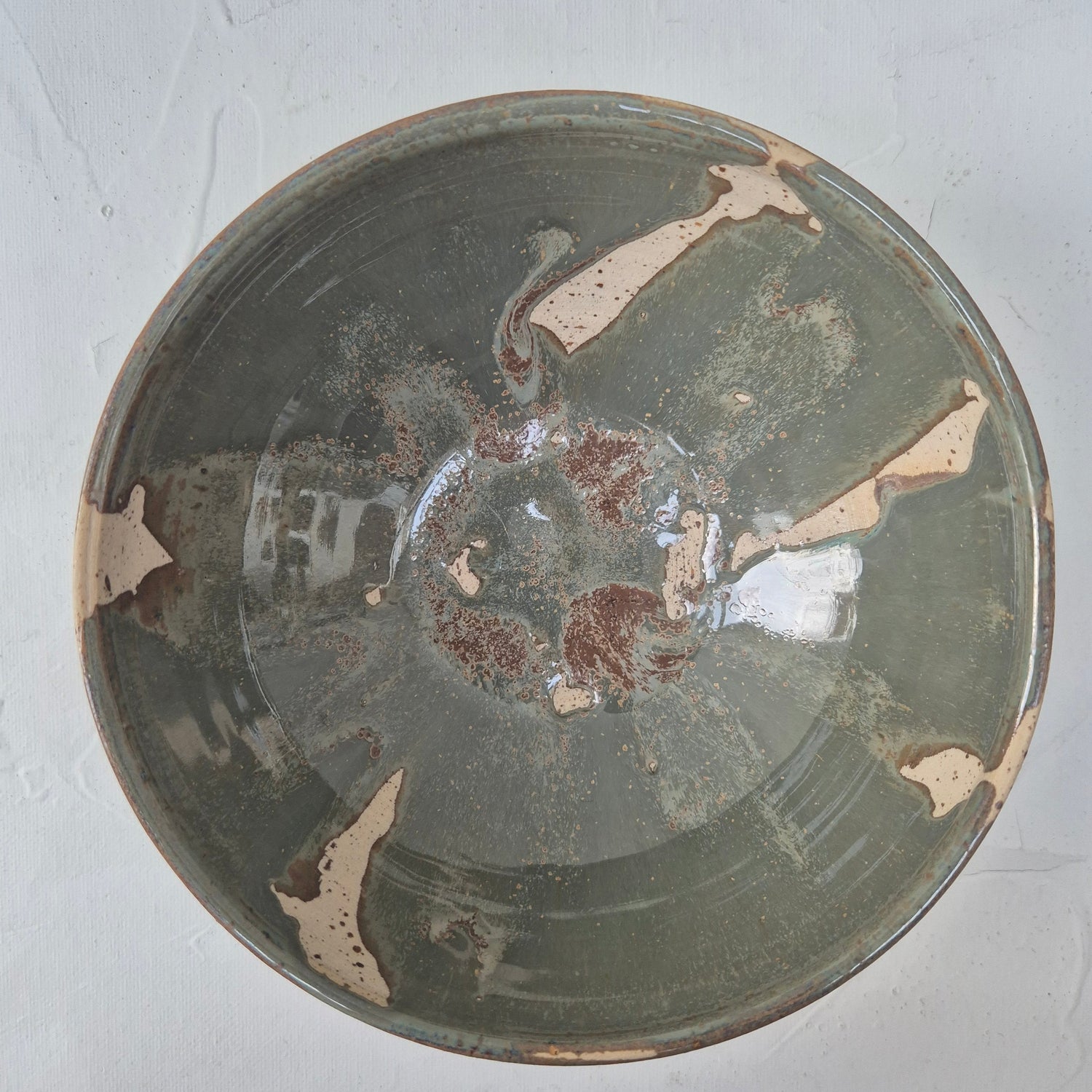 Decorative ceramic plate with brown and beige patterns on a white background