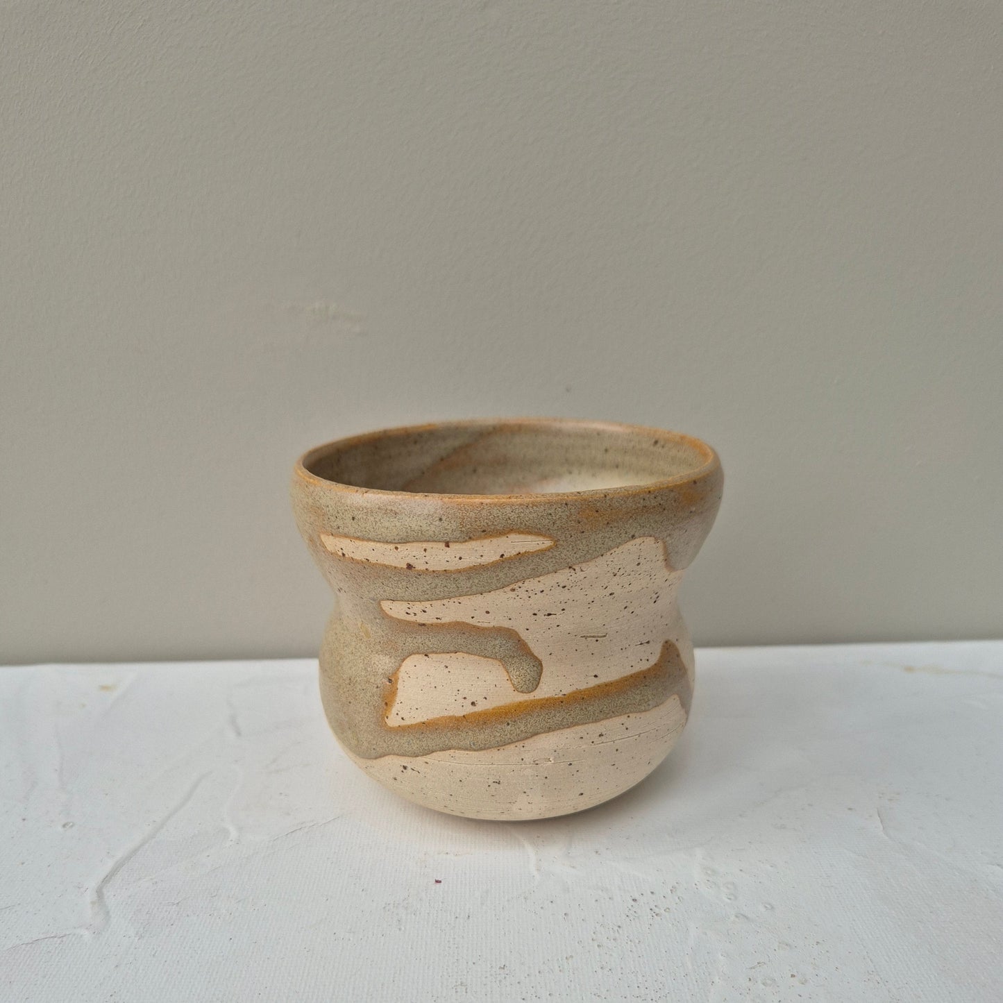 Ceramic cup with abstract design on a light gray background